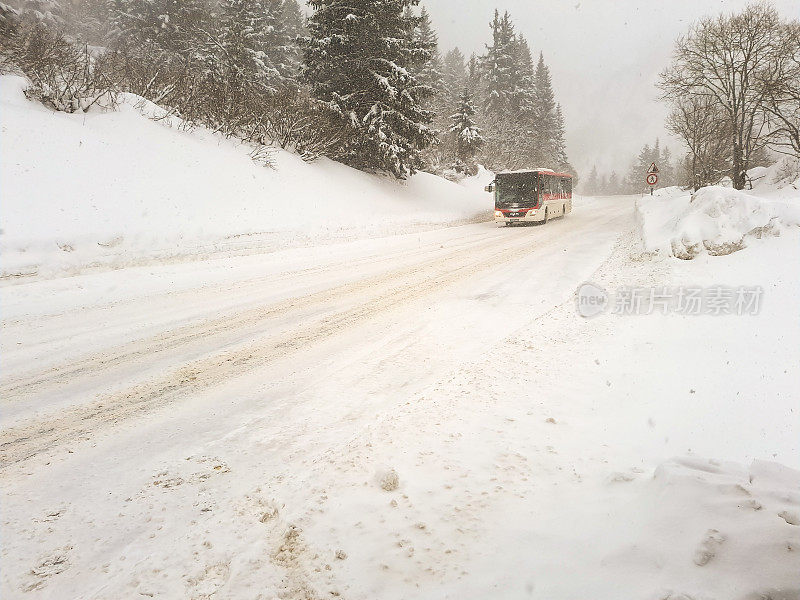 在暴风雪天气下，沿着法国Les arc的积雪覆盖的道路旅行，道路两侧都有美丽的积雪覆盖的树木。